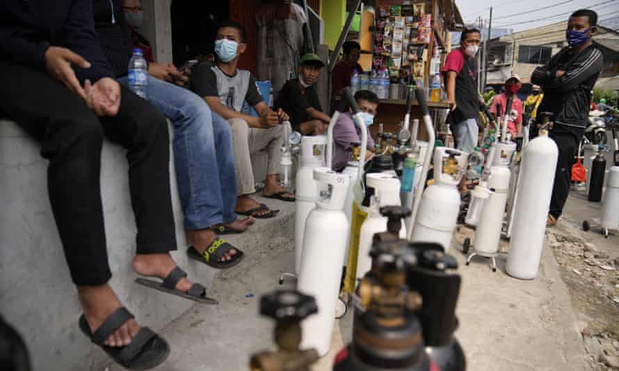 Orang-orang mengantri untuk mengisi tabung oksigen mereka di Jakarta