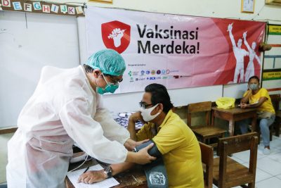 Seorang petugas kesehatan memeriksa seorang pria sebelum menerima dosis vaksin virus corona (COVID-19) selama program vaksinasi di Jakarta, Indonesia, 17 Agustus 2021 (Foto: REUTERS/Ajing JD Ulviana).