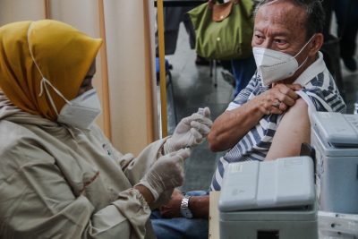 Seorang pria bersiap menerima dosis vaksin COVID-19 Pfizer di Bandung, Indonesia, 28 Juli 2022 (Foto: REUTERS/Alji Vibri Sugita).