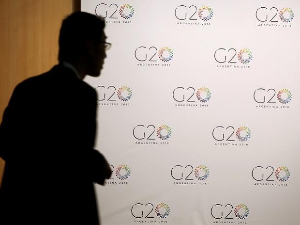 A man stands next to a board with the G20 Meeting of Finance Ministers logo in Buenos Aires, Argentina. Photo: Reuters
